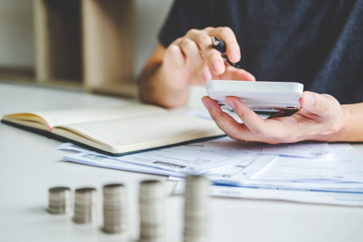 Man using calculator Accounting Calculating Cost Economic bills with money stack step growing growth saving money in home , finance concept